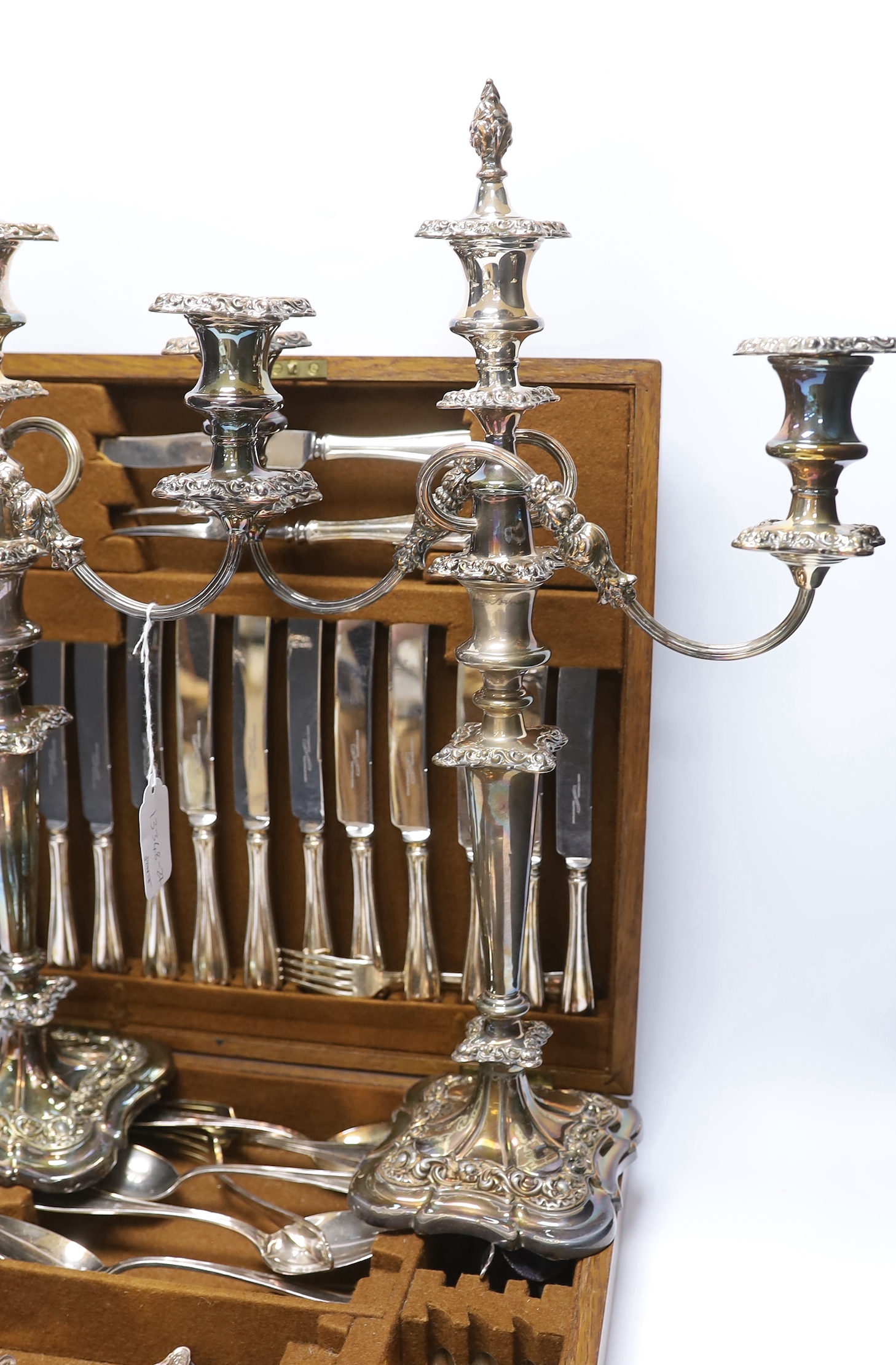 An oak cased canteen containing Sheffield ‘Super stainless’ flatware and a pair of plated candelabra, 46cm
